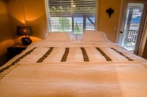 duże białe łóżko w pokoju z oknem w obiekcie The Fraser River's Edge B&B Lodge w mieście Chilliwack