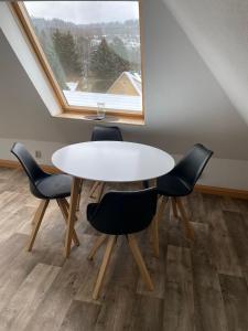 - une table et des chaises dans une chambre avec fenêtre dans l'établissement FeWo Rennsteigschloß, à Benshausen