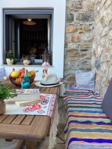 a patio with two benches and a stone wall at Casa Charma in Émbonas