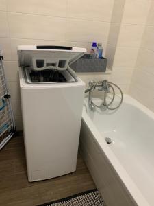 a white trash can sitting next to a bath tub at Ländliche Idylle in Neu Bötzow