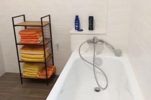 a bathroom with a bath tub and a rack of towels at Ländliche Idylle in Neu Bötzow