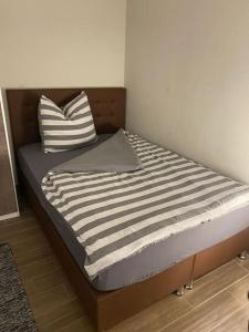 a bed with a striped mattress and a pillow on it at Ländliche Idylle in Neu Bötzow