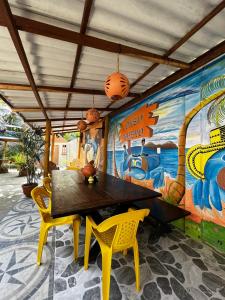 une salle à manger avec une table et des chaises ainsi qu'une fresque murale. dans l'établissement Alojamiento Bityn, à Paso Nuevo