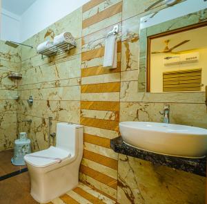 y baño con aseo y lavamanos. en MARINA SUITES AIRPORT HOTEL en Kochi