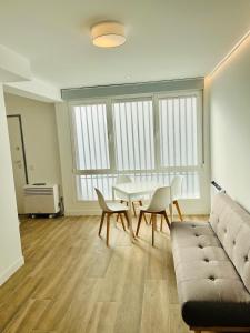a living room with a table and a couch at BERNABEU/ C.UNIVERSITARIA APARTMENTS in Madrid