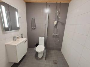 uma casa de banho com um chuveiro, um WC e um lavatório. em Bright studio apartment on the 6th floor em Kerava