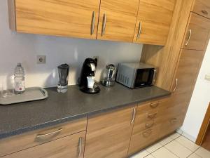 eine Küchentheke mit Kaffeemaschine und Mikrowelle in der Unterkunft Komplettes Apartment - 2 Zimmer Wohnung in Kehl am Rhein