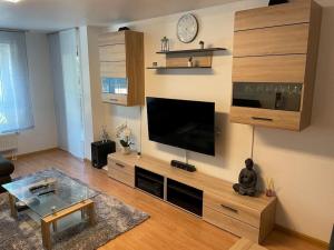 ein Wohnzimmer mit einem großen Entertainment-Center mit einem Flachbild-TV in der Unterkunft Komplettes Apartment - 2 Zimmer Wohnung in Kehl am Rhein