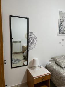 a mirror on a wall next to a bed and a table at La villetta 2.0 in Rende