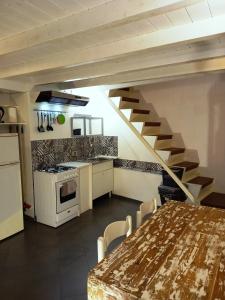 uma cozinha com uma mesa e uma escada num quarto em Residenze Palazzo Pes em Cagliari