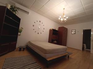 a bedroom with a bed and a clock on the wall at Veszprem city center in Veszprém