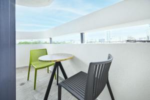 a small table and chairs on a balcony with a view at Summer White by HolyGuest in Tel Aviv