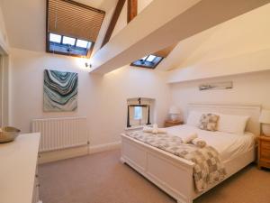 um quarto com uma cama e duas janelas em Barley Mews em Weymouth