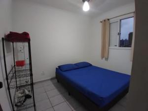 - une chambre avec un lit bleu dans l'établissement Apartamento Vista 500mts do Mar - Comércio Próximo, à Praia Grande