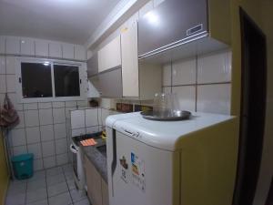 Elle comprend une petite cuisine équipée d'un réfrigérateur et d'un bol. dans l'établissement Apartamento Vista 500mts do Mar - Comércio Próximo, à Praia Grande