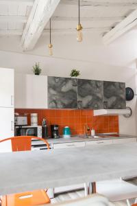 a kitchen with orange and gray tiles on the wall at Design Center Florence APT - HomeUnity in Florence