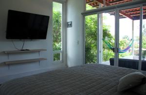 una camera con letto e TV a schermo piatto di Villa Coiros Bici, Hospedaje y Bienestar a Tonatico