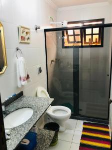 y baño con ducha, aseo y lavamanos. en Casa familiar en Arraial do Cabo