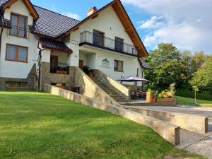 una casa con una escalera de piedra frente a un patio en Dwór Bysina, en Myślenice
