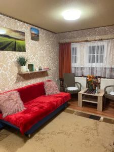 a living room with a red couch in a room at Haus ZUR PINGE in Kurort Altenberg