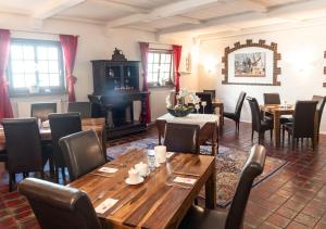 a restaurant with wooden tables and chairs and a fireplace at Hotel Rosenhof GmbH in Ramstein-Miesenbach