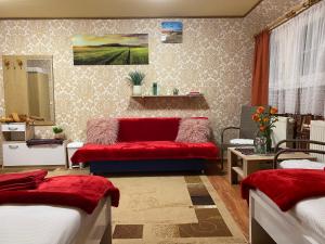 um quarto com 2 camas e um sofá vermelho em Haus ZUR PINGE em Kurort Altenberg