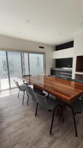 a dining room with a large wooden table and chairs at Casa Atilio -Dpto Premium con entrada autónoma in Rafaela