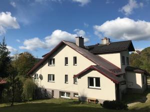 uma casa branca com um telhado preto em Zakątek em Wysowa-Zdrój