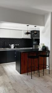 a kitchen with black and white cabinets and a counter at Casa Atilio -Dpto Premium con entrada autónoma in Rafaela