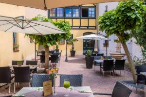 Weidaにあるzur altstadtの中庭のテーブルとパラソル付きのレストラン