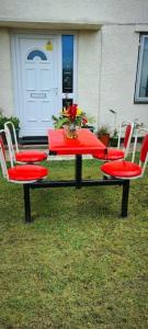 a table with two chairs and a table with a vase on it at Cuisinease in Ollerton