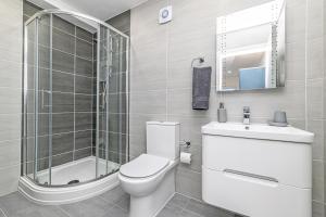a bathroom with a toilet and a shower and a sink at Eden Grove Holiday Homes in Kirkby Thore