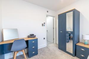 a blue desk with a mirror and a blue chair at Eden Grove Holiday Homes in Kirkby Thore
