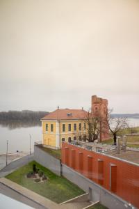 ein gelbes Gebäude neben einem Wasserkörper in der Unterkunft Danube Paradise in Vukovar