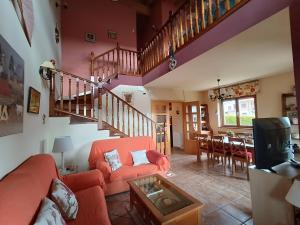 a living room with a red couch and a staircase at Cuarenta y Ocho Luces in Burgos