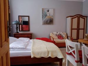 um quarto com uma cama, uma cadeira e uma mesa em Sunny Bear Bed & Breakfast em Jelenia Góra