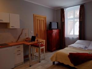 a bedroom with a bed and a desk with a laptop at Sunny Bear Bed & Breakfast in Jelenia Góra