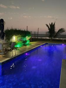 una gran piscina azul con vistas al océano en Ondas de Itacimirim, o paraíso é aqui! Pé na areia, en Itacimirim