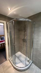 um chuveiro com uma caixa de vidro num quarto em The Hinds Head Hotel em Chorley