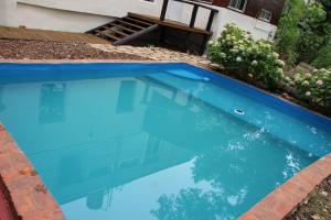 une grande piscine bleue en face d'une maison dans l'établissement CASA EDÉN exclusiva y cómoda casona de descanso a tan solo 1 hora de Bs As, à Tigre