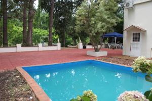 une piscine bleue en face d'une maison dans l'établissement CASA EDÉN exclusiva y cómoda casona de descanso a tan solo 1 hora de Bs As, à Tigre