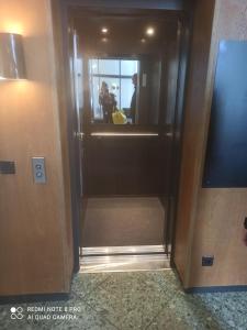 uma porta de elevador com um reflexo de uma pessoa no espelho em Haus Zerfreila em Vals