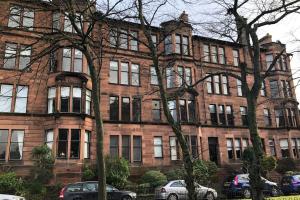 a large brick building with cars parked in front of it at Spacious 3 bed flat in the heart of the west end. in Glasgow