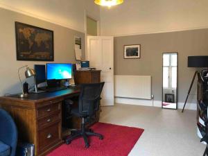 an office with a desk with a computer and a chair at Spacious 3 bed flat in the heart of the west end. in Glasgow