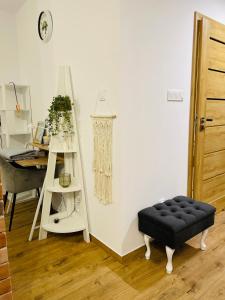 a black ottoman in a room with a desk and a ladder at NaturaApart bezpłatny parking in Ostrołęka