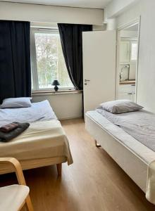 een slaapkamer met 2 bedden en een raam bij Apartment Mariankatu in Kokkola