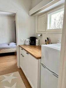 een keuken met witte kasten en een raam en een bed bij Apartment Mariankatu in Kokkola