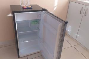 an empty refrigerator with its door open in a kitchen at Casita Independiente, Ubicada Atrás de Nuestra Casa in David
