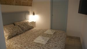 una camera da letto con un letto e due asciugamani di La Mansio del Vicolo a Mola di Bari