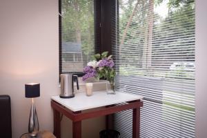 uma mesa com flores ao lado de uma janela em Little Paradise em Stelle